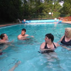 People enjoying themselves in an outdoor pool.
